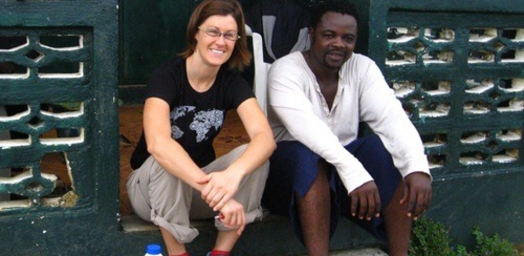 A man and a woman sit on steps of a house in Liberia