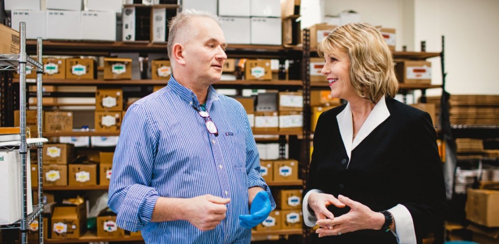 Older man and woman speak to each other in a storage room