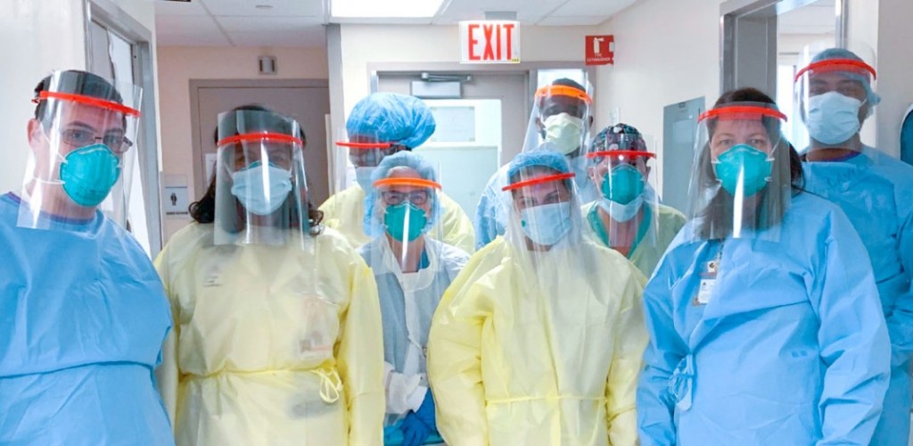 9 standing medical staff workers pose