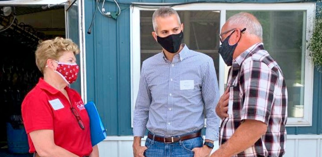 a women and two men standing outside talking 