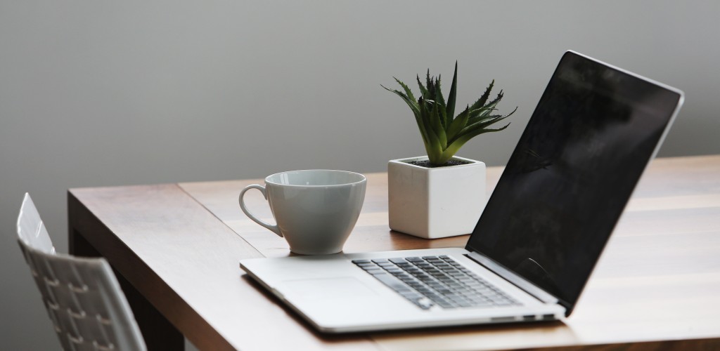 Desk with laptop, plant and coffee cup