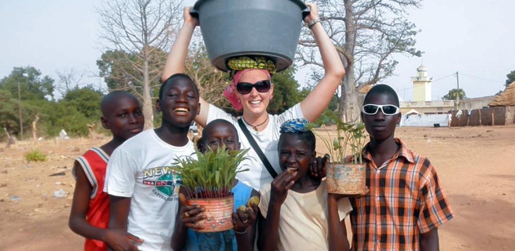 A student standing with five children outside in Africa 