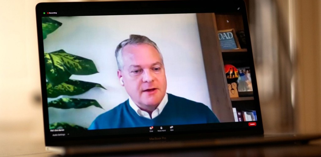 Chris Barrett speaking during a webinar on a labtop