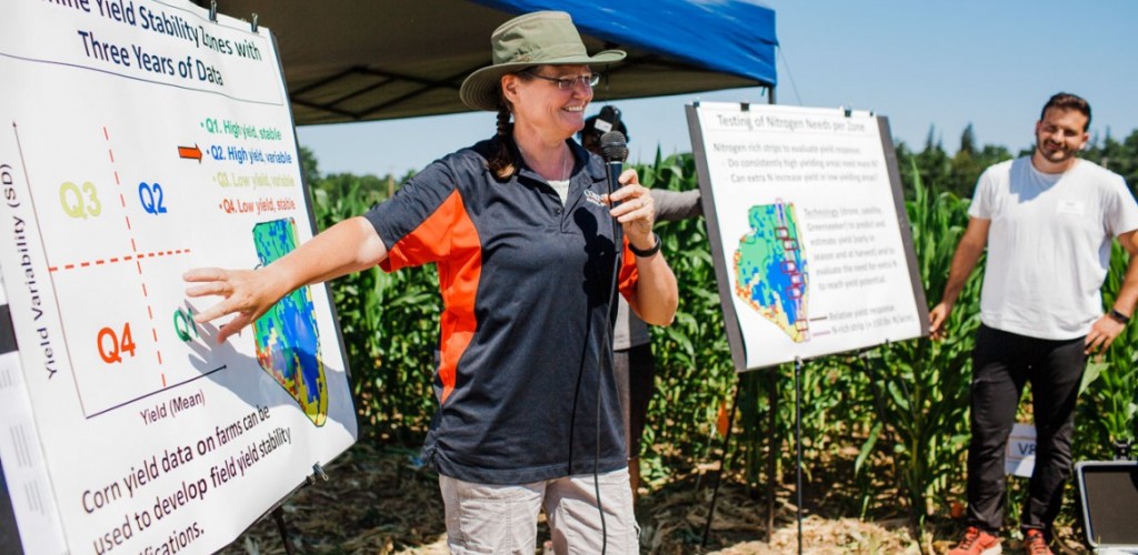 Quirine Ketterings standing in front of a poster outside speaking into a microphone