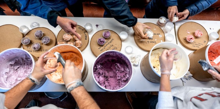 Teaching assistants scoop out the ice cream flavors and hand them to students 