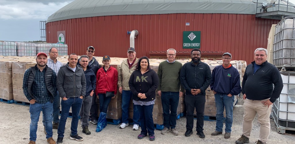 Group standing in front of an anaerobic digester at a Western NY dairy farm