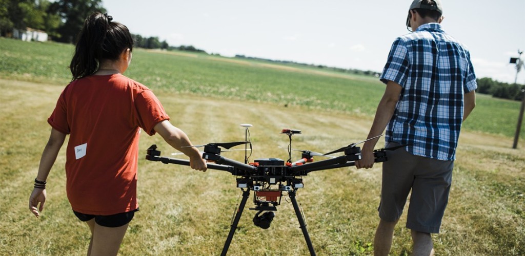 Two people holding a drone.