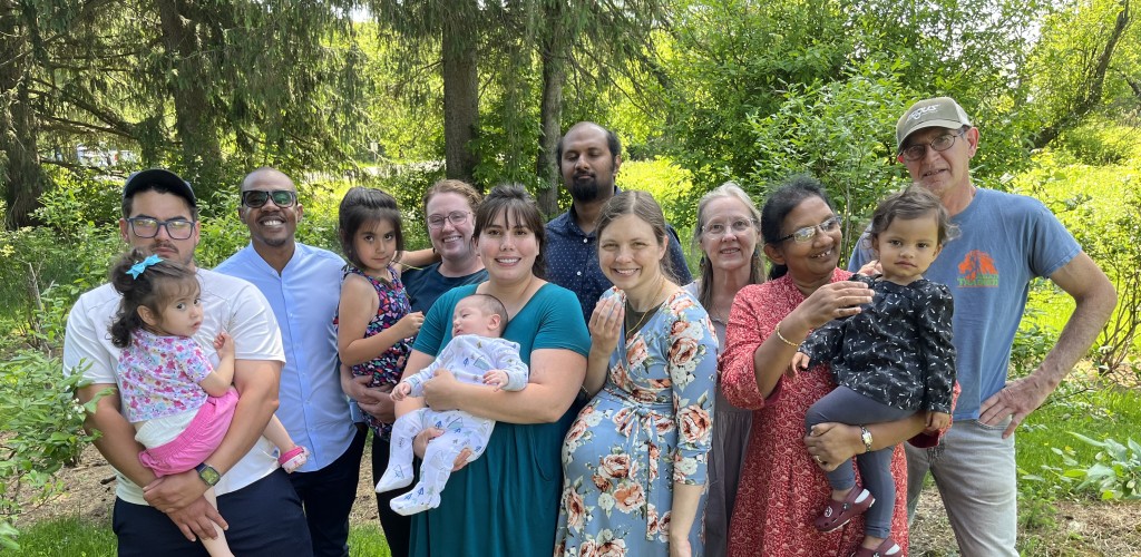 Group poses for photo in front of tree