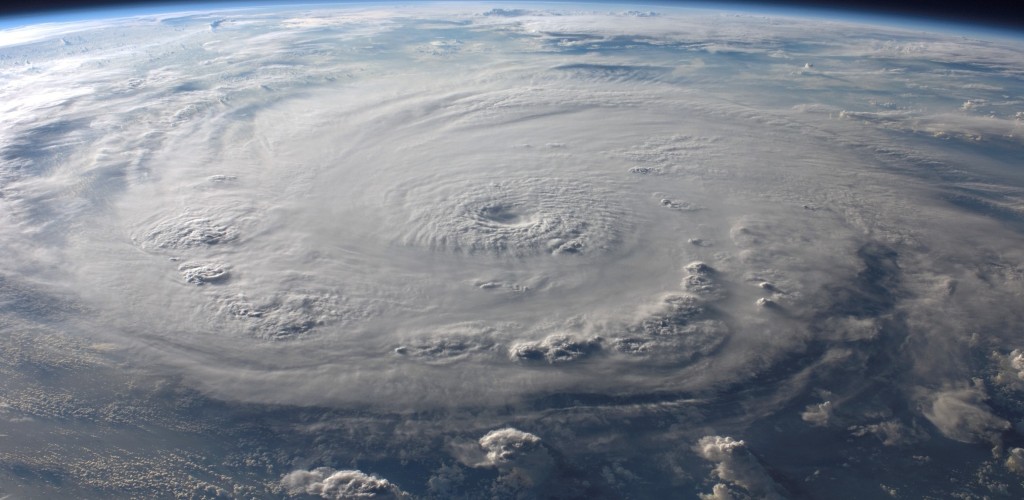 Earth viewed from outer space, a large cloud swirl is forming in the center of the atmosphere.