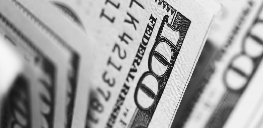 A bundle of one hundred U.S. dollar bills from the side.