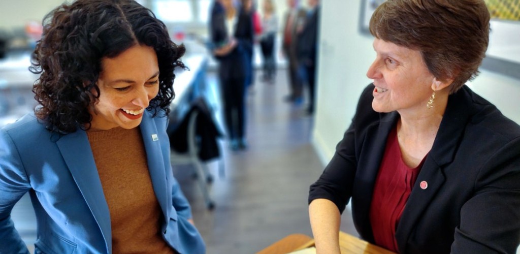 Two women have a conversation and laugh.