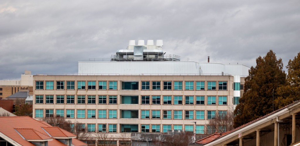 The outside of the Biotechnology Building on a grey cloudy day. It is a building with five floors, peach concrete walls, and sixteen windows per floor covering the entire span of the building.  