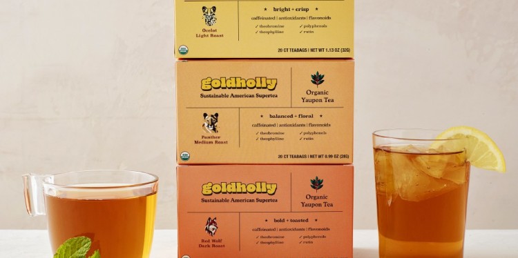 Three boxes of tea bags along with two cups of prepared tea. 