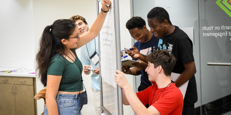 Youths working together on a whiteboard