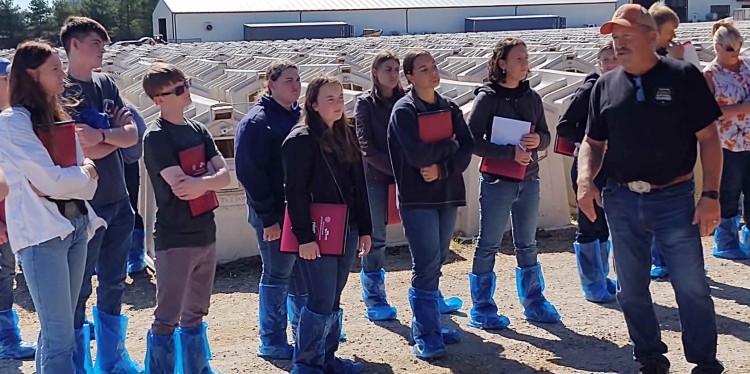 students on a tour in front of calf hutches