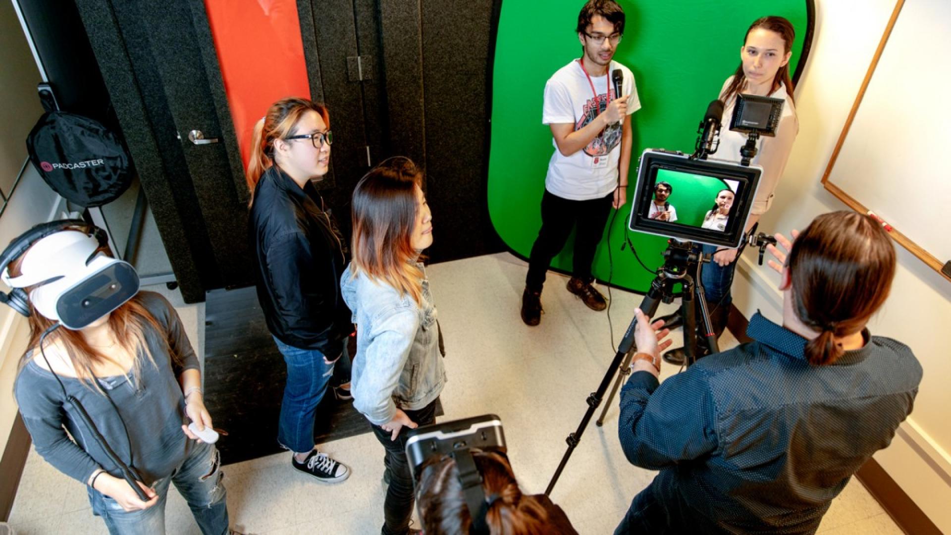 Male and female students working in a multimedia studio with a camera 