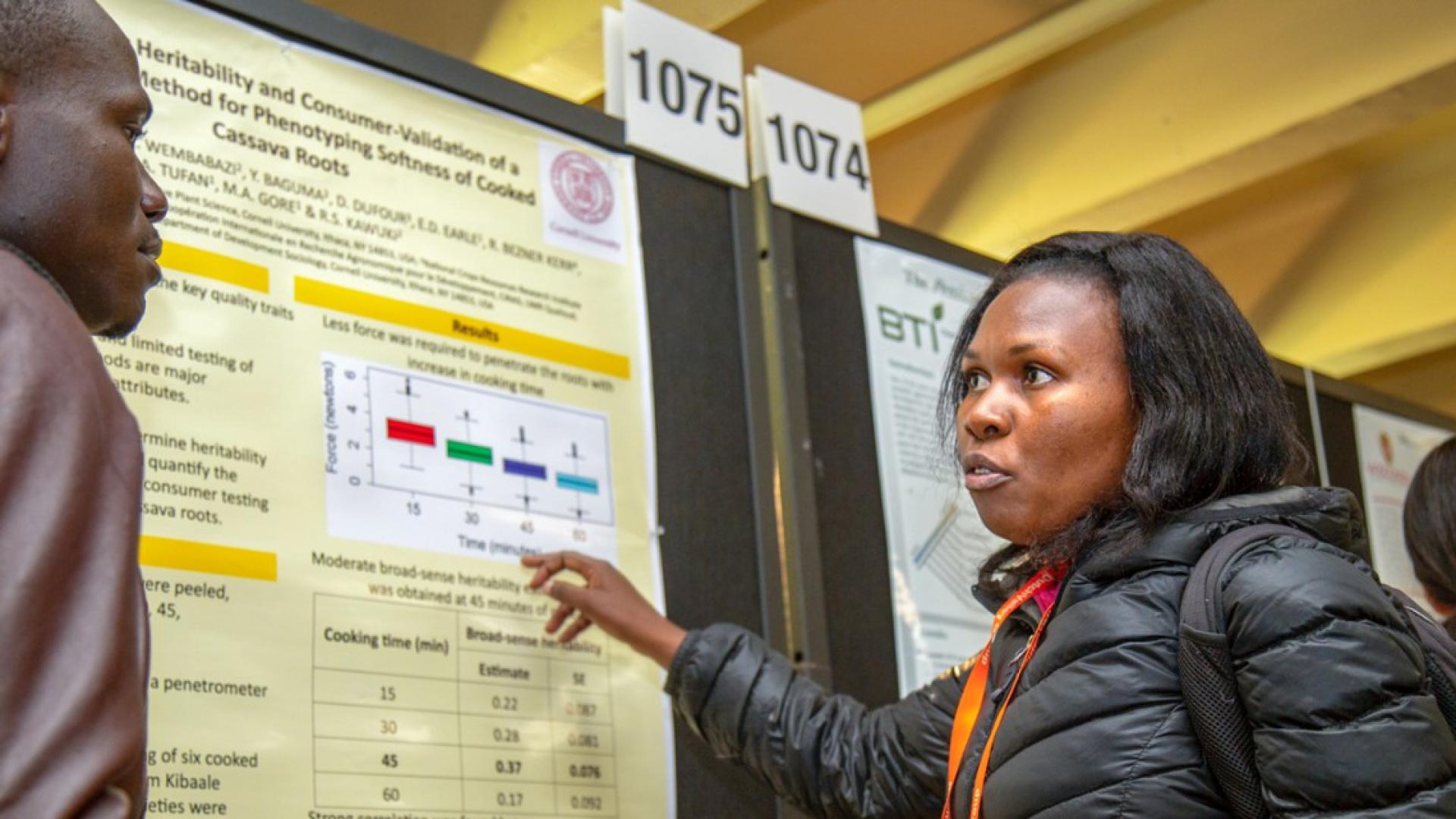 A woman presenting an academic poster to a man 