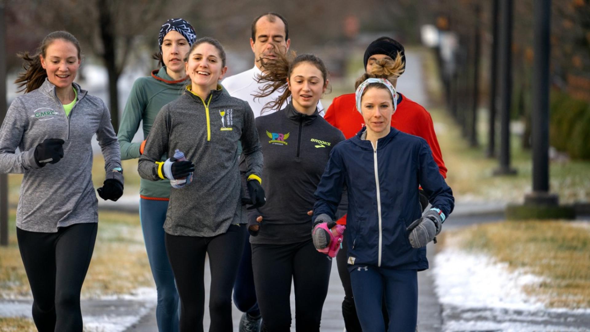 Men and women running down an empty road