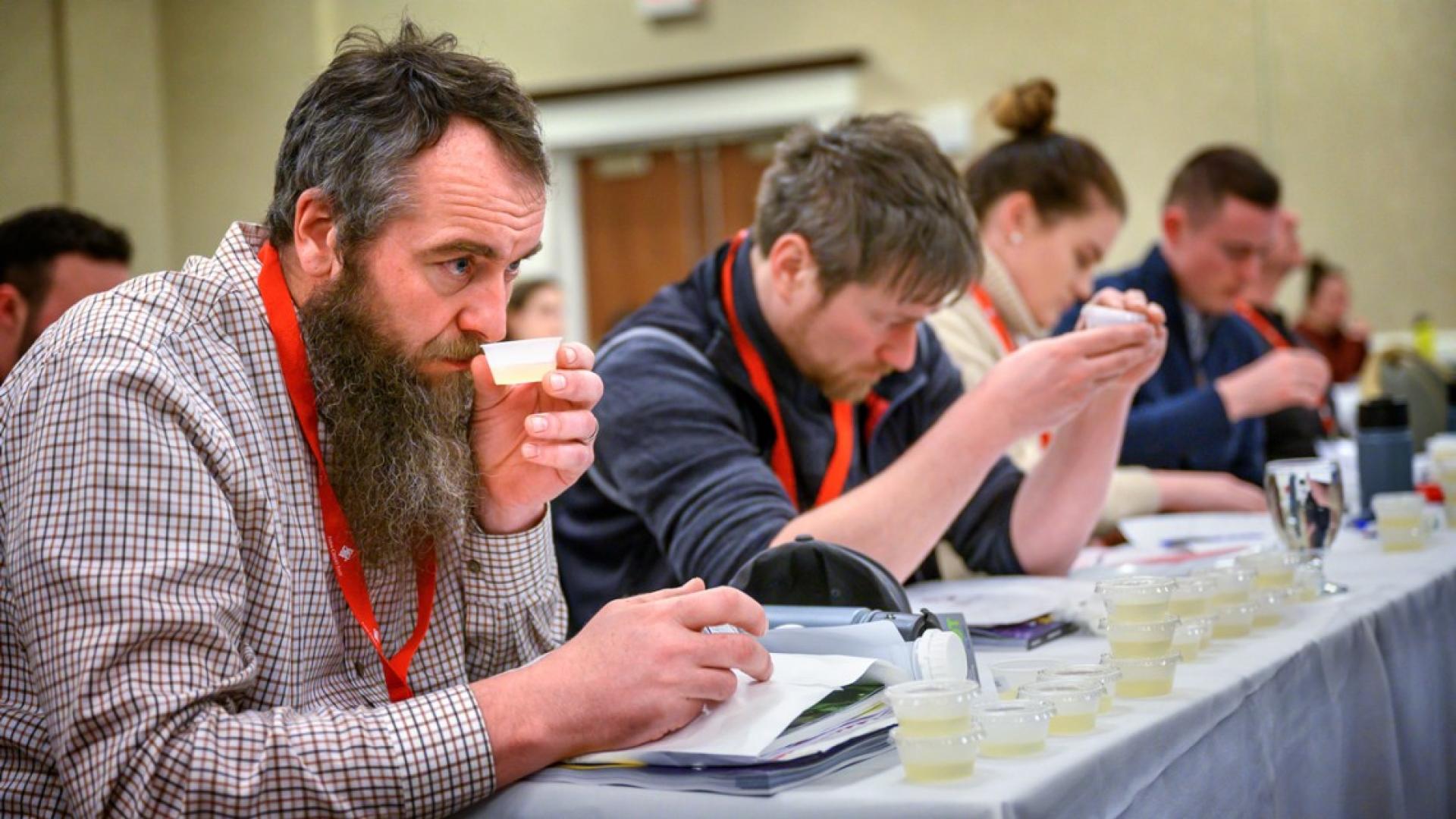 Men and women sitting at a table sampling wine