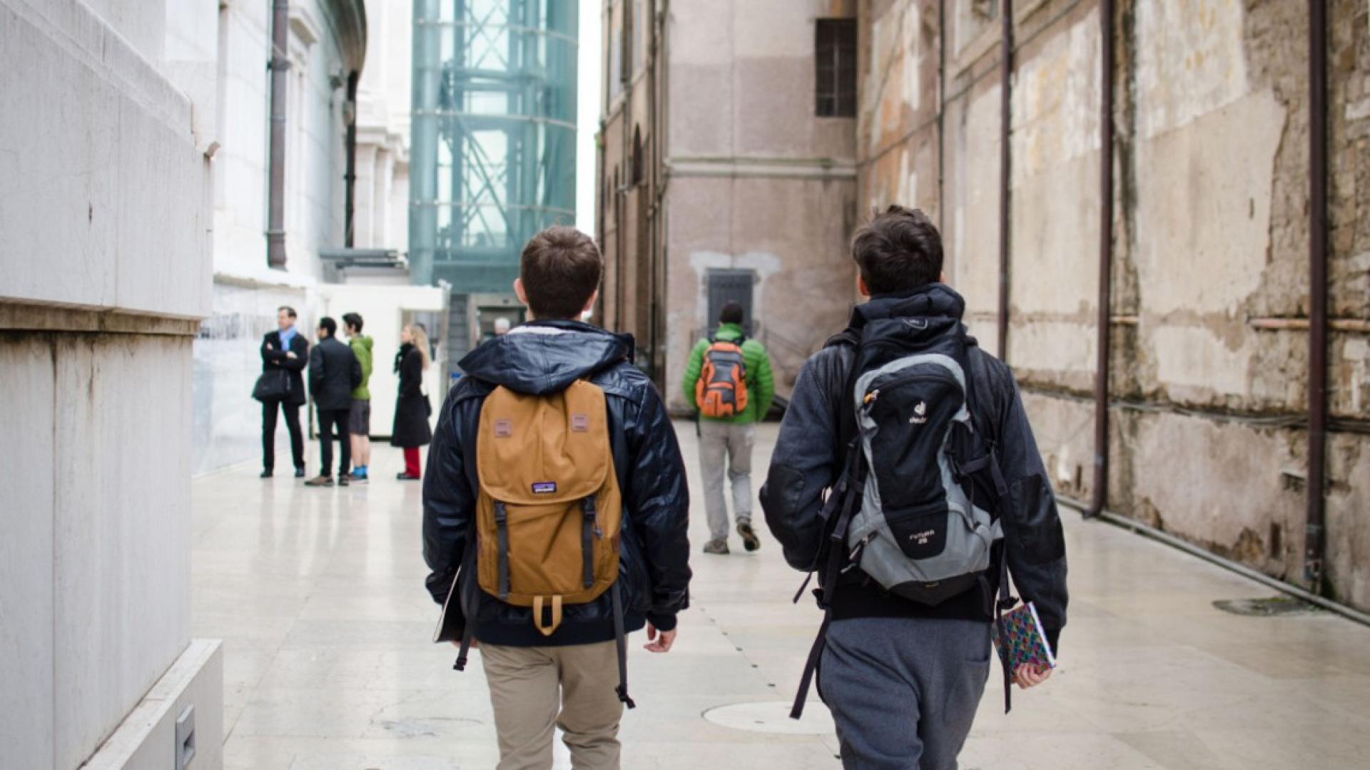Two male students walking by a monument 