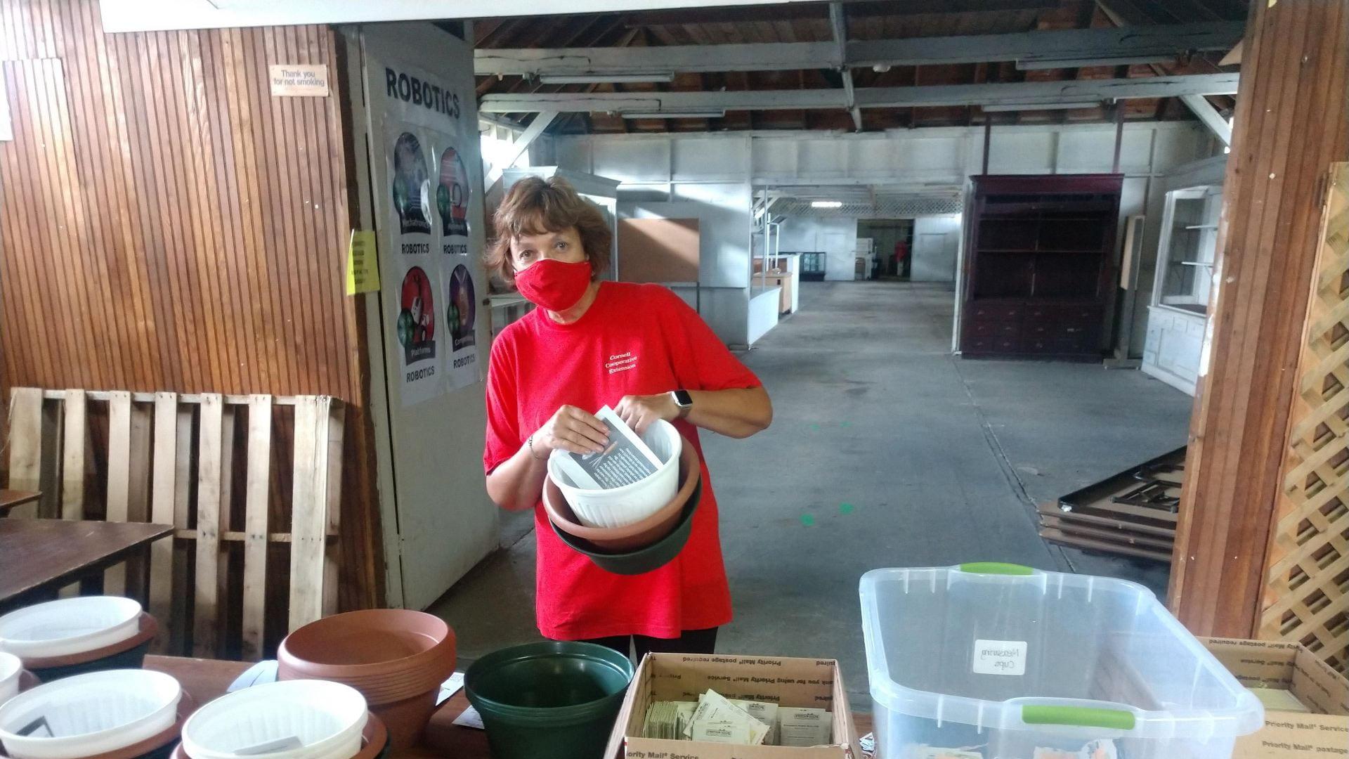 a woman behind a table making a container garden