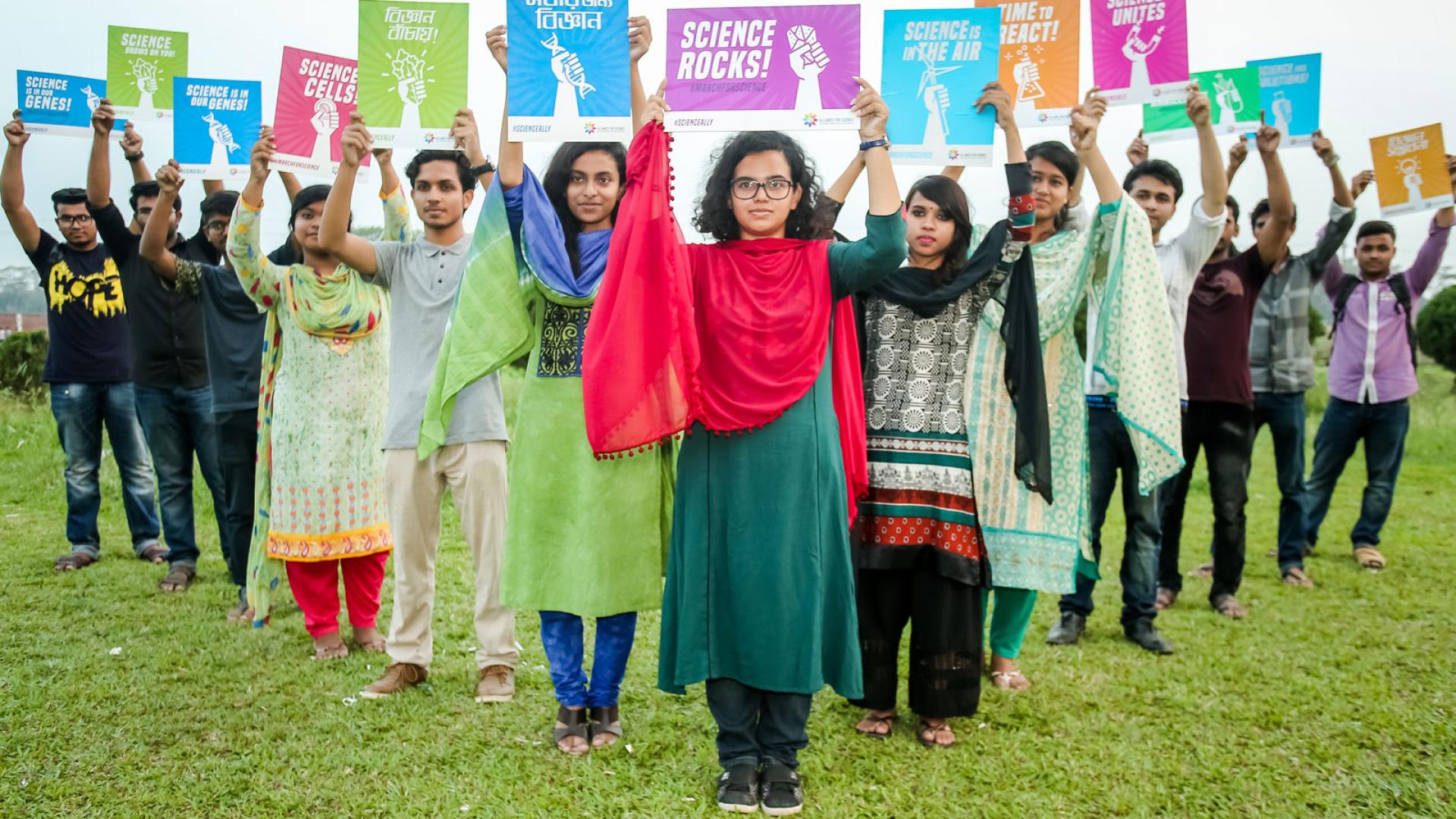 People hold signs in support of science