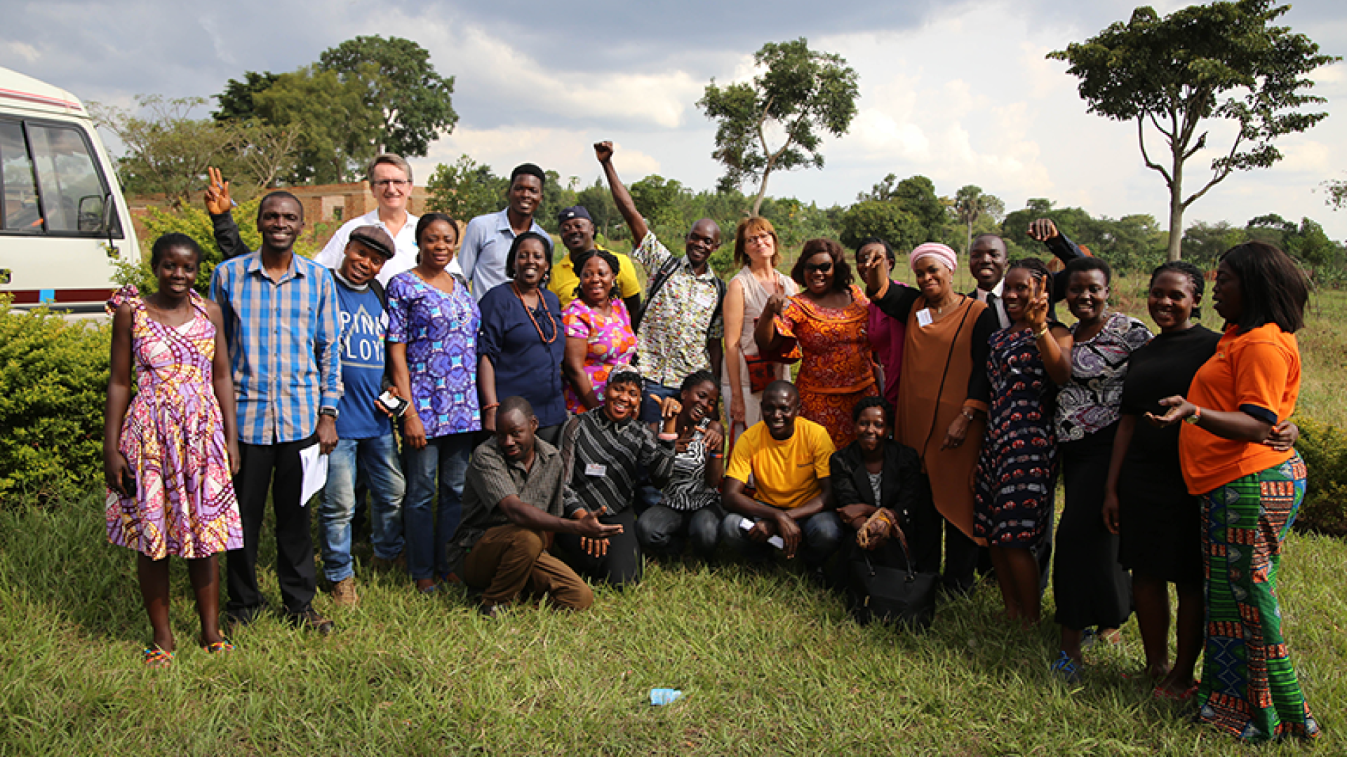 A group poses in a field in Africa