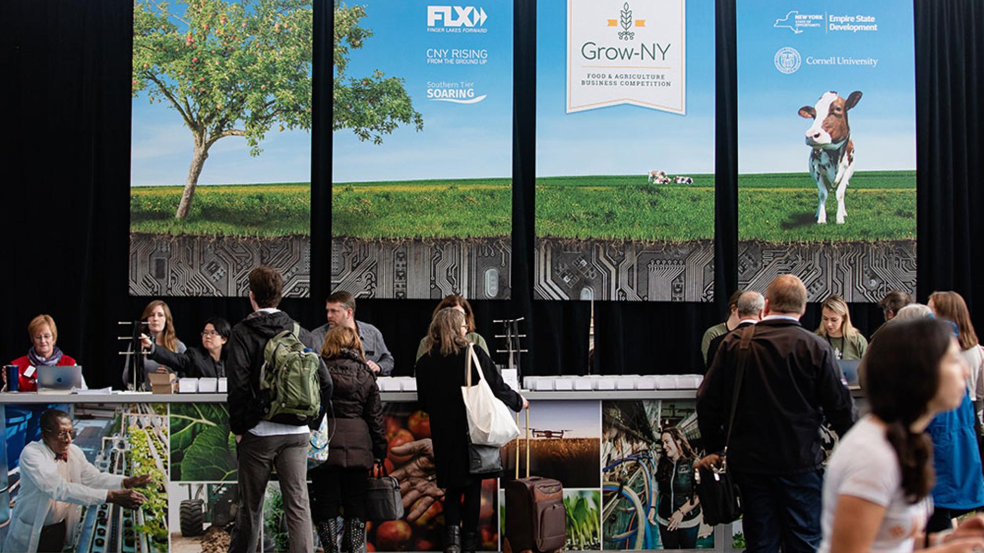 People standing in an event lobby checking in at a desk