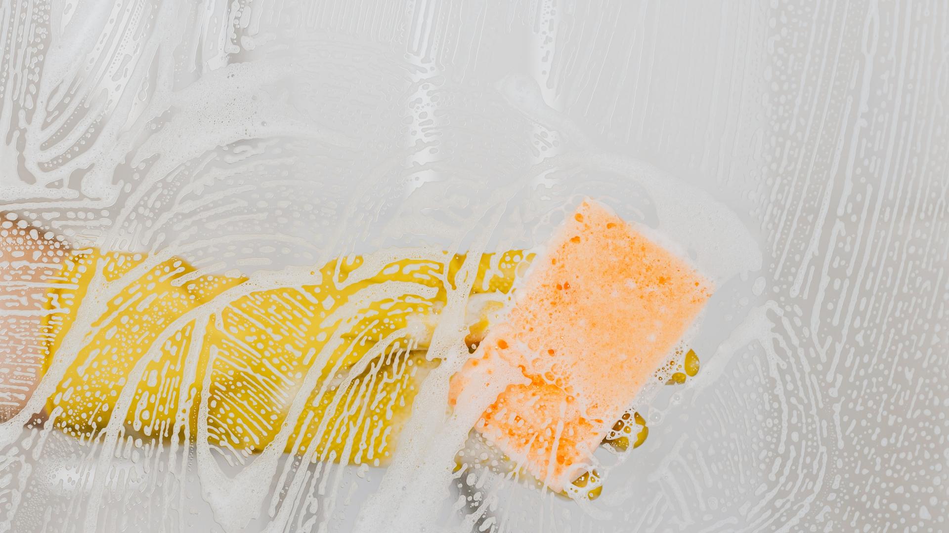 A gloved hand cleans a glass surface