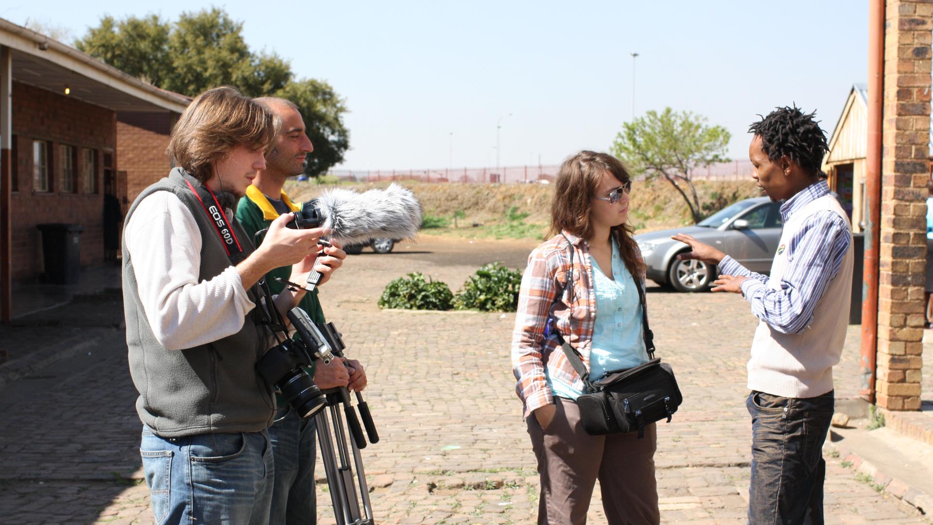 Three individuals film a documentary