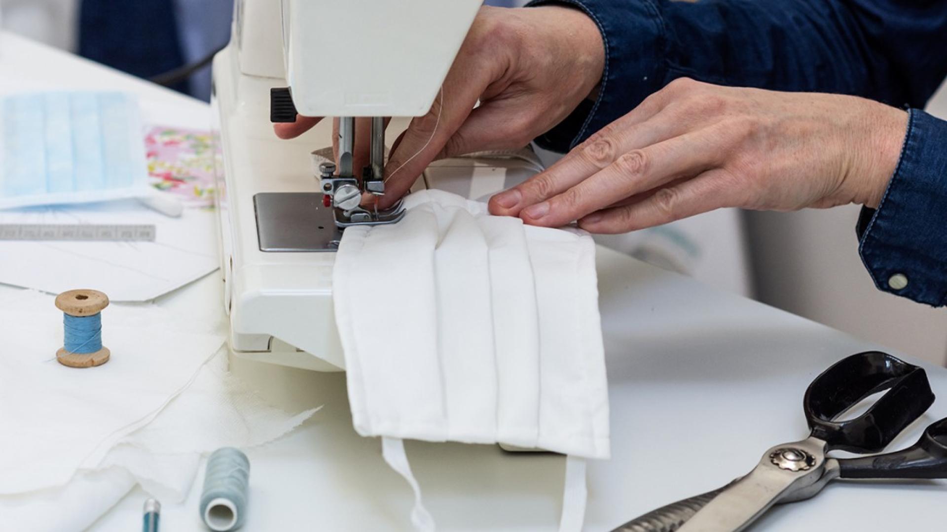 Hands working a sewing machine