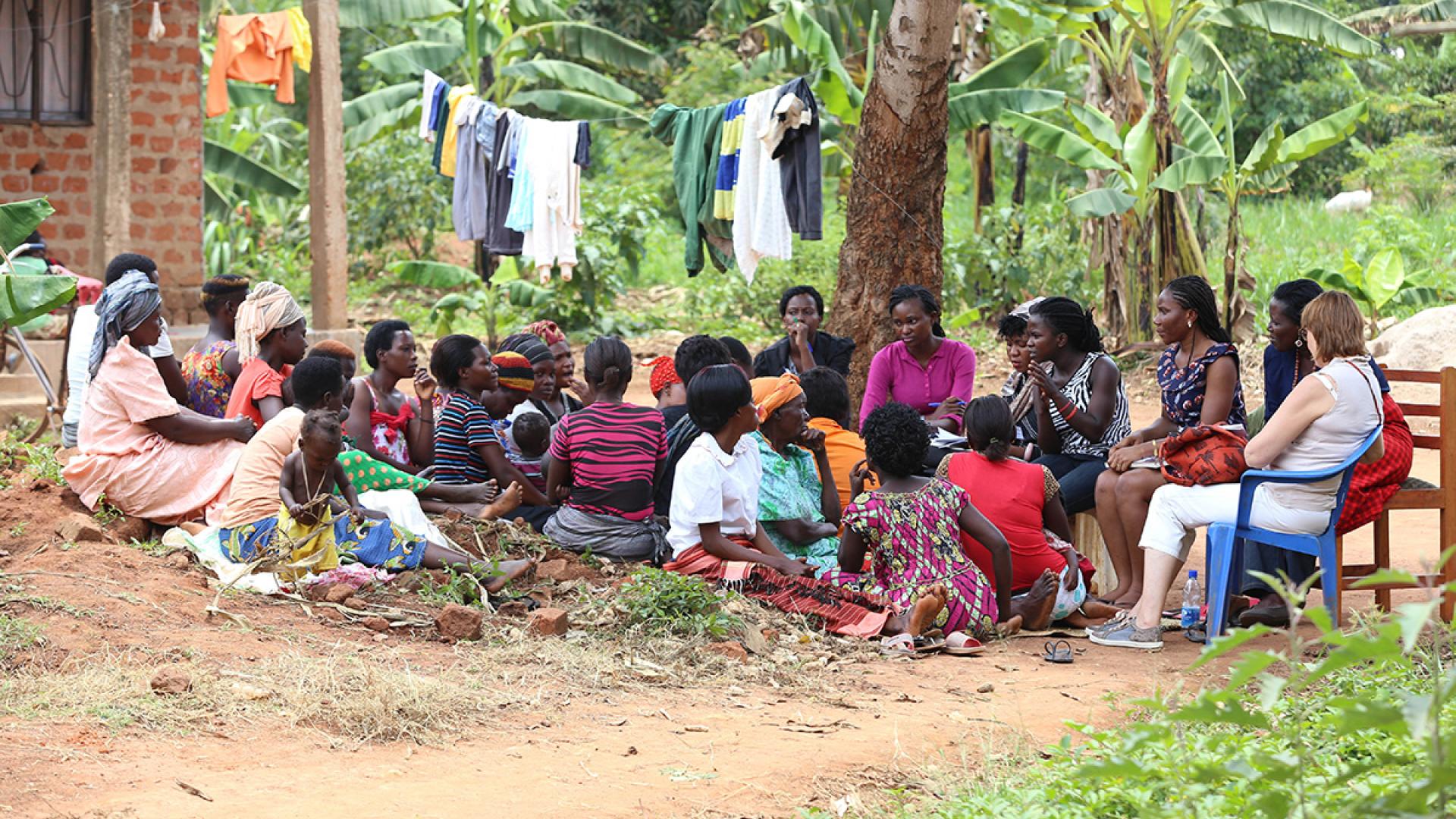 A group sits outside near a tree