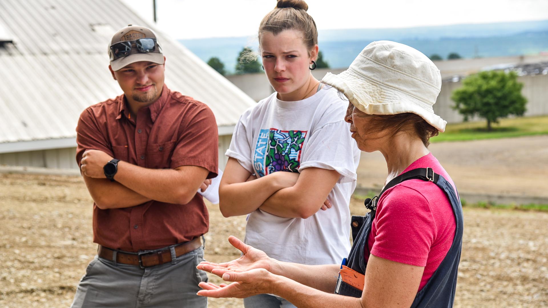 three people talking on a farm