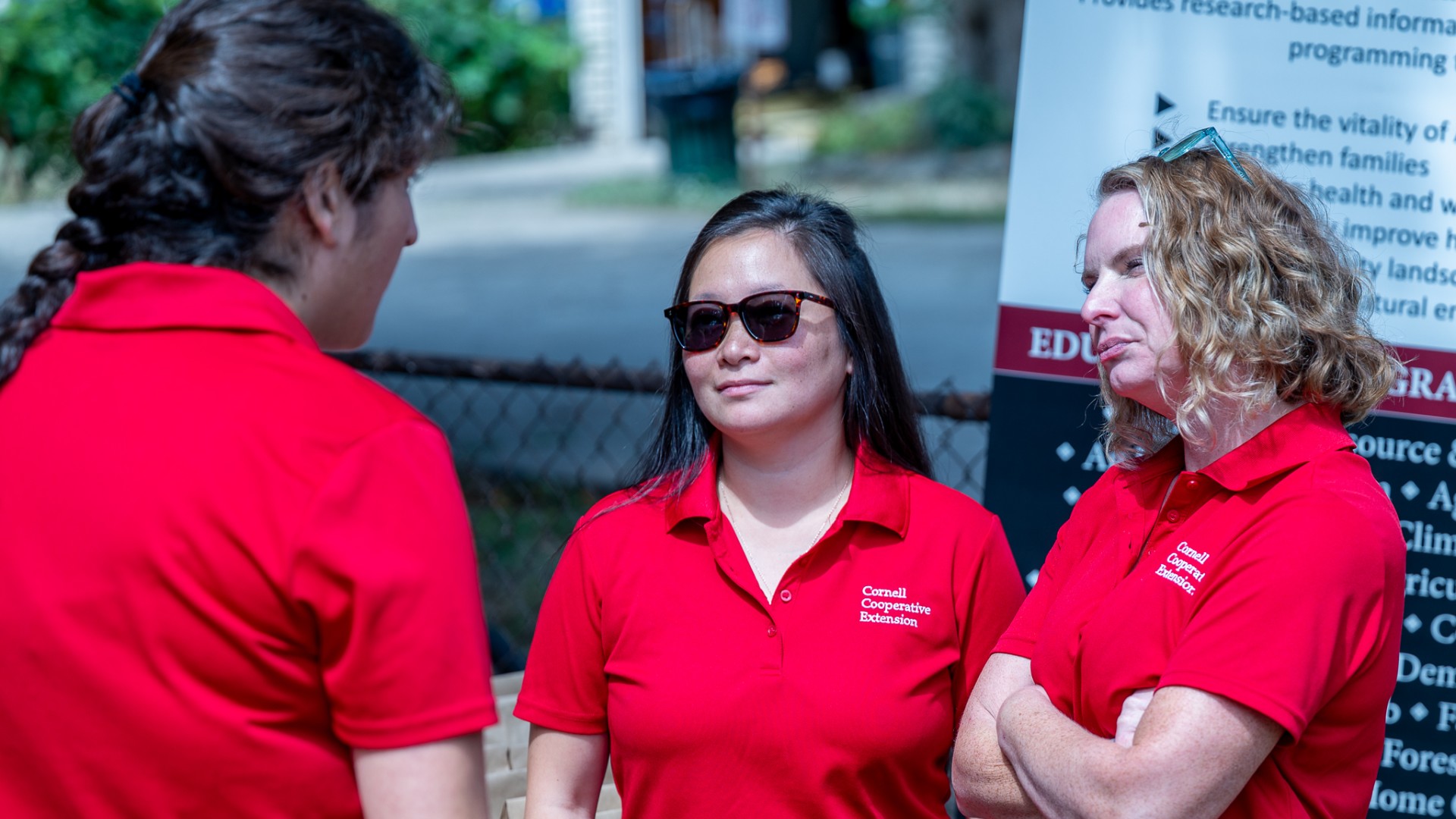 Mallory Hohl speaks with colleagues at the South Lawn garden in Rochester, NY.