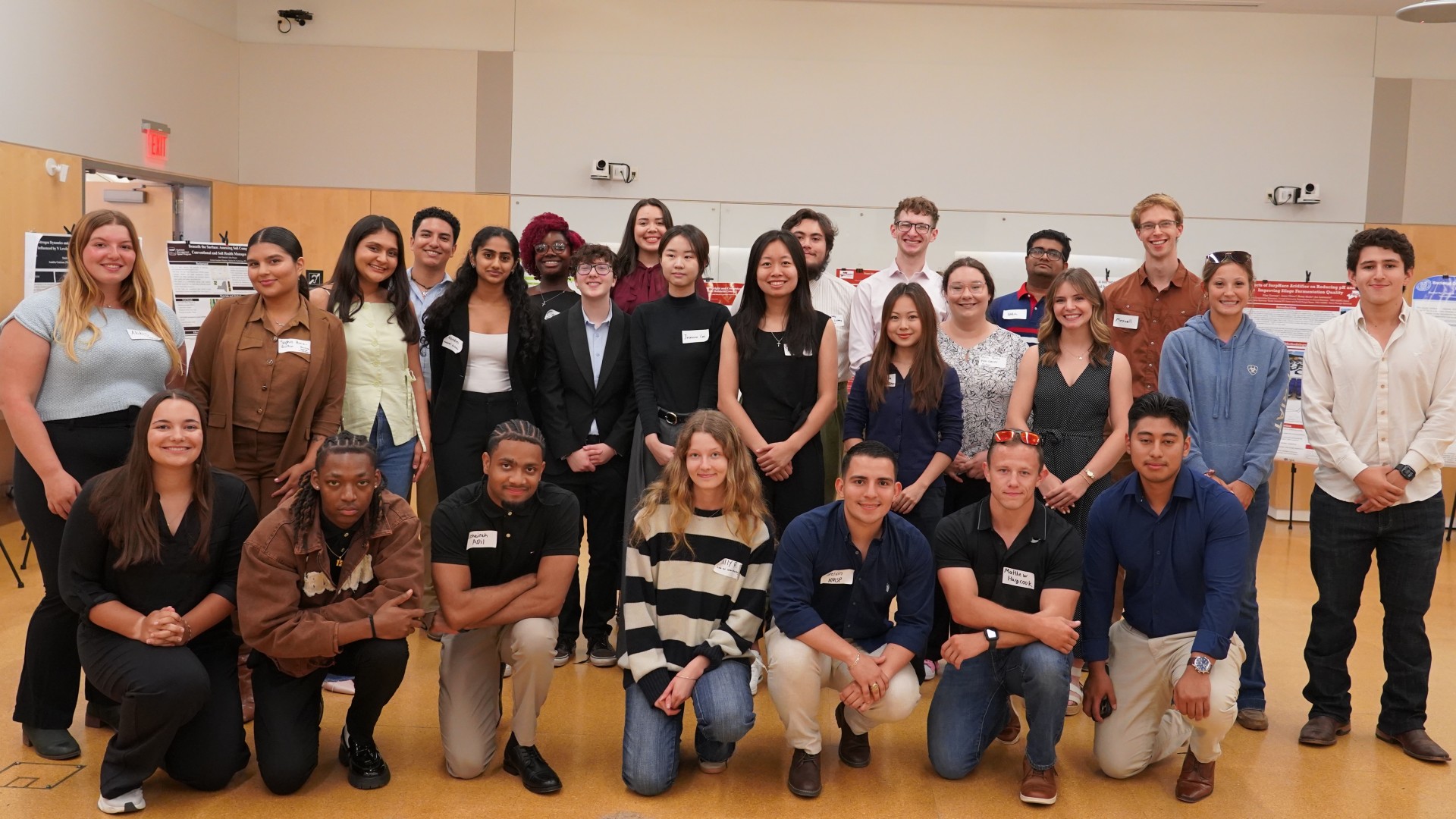 A group of people stand in two lines, each individual posing for the group photo.