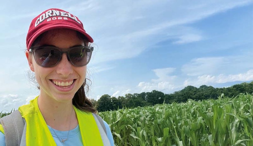 photo pf a smiling person's headshot wearing sunglasses and an orange hat