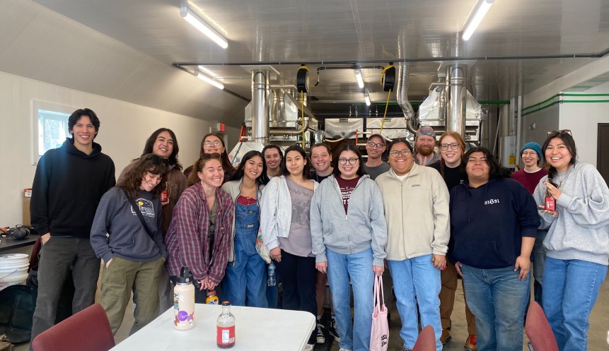 Students stand in a maple syrup processing plant.