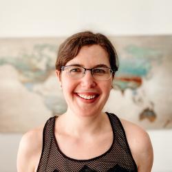 Megan Greischar standing in a room with a map on the wall behind her