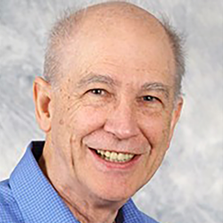 a portrait of a smiling man in a blue shirt