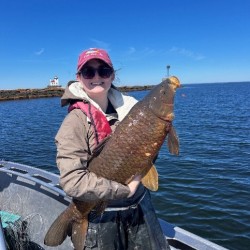 Samantha LaSalle holding a fish on a lake 