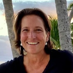 Angela Fuller smiling face in front of tropical scene