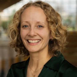 person smiles in front of blurred background