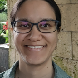 person smiles in front of wall background