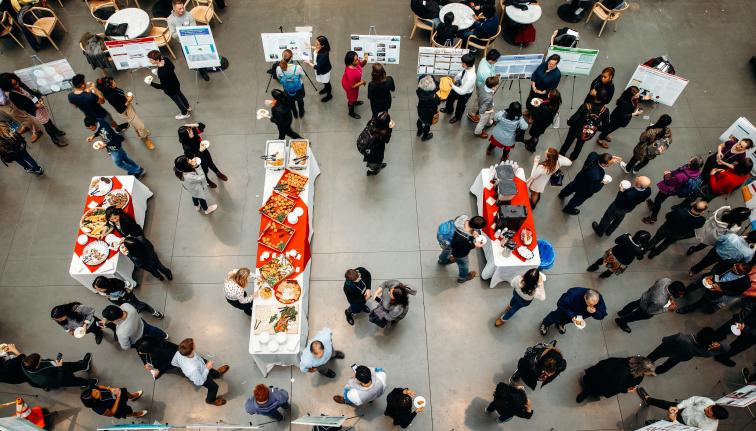 Aerial view looking down at the atrium in Klarman Hall where students present project posters to community members.