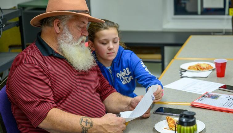 Man and granddaughter reading together