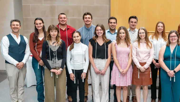 Group of people standing in front of a grey wall