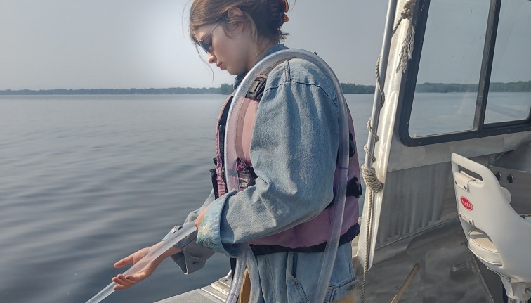 person collecting water samples from lake