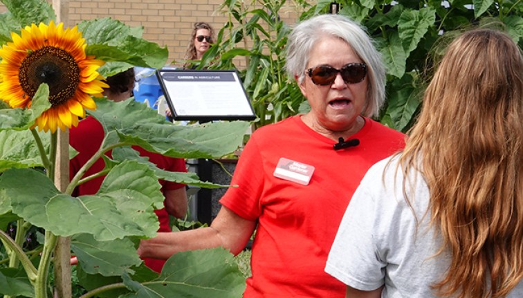 Woman talking to youth girl with sunflower in the background