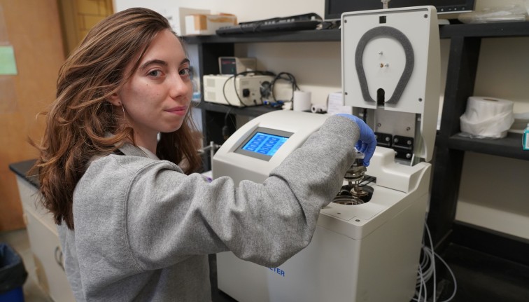 a woman puts a sample into a bombcalorimeter