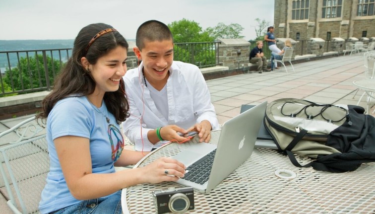 2 students look at a laptop computer